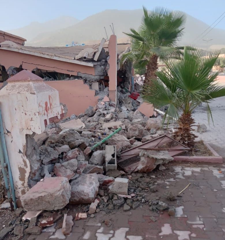 Rubble surrounds a collapsed building.