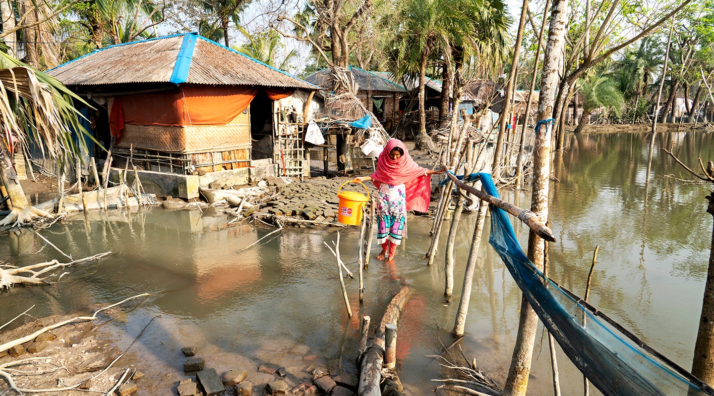 Farzana wades through floodwaters in Uttar-Bedkashi in the Khulna District. 